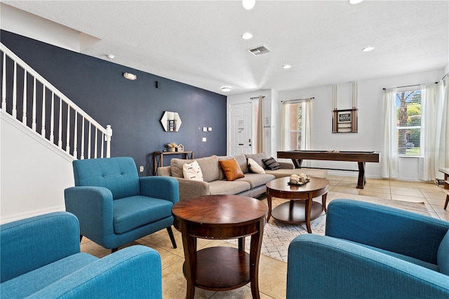 living room featuring billiards, light tile patterned floors, and a textured ceiling