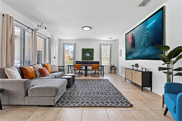 living room with a textured ceiling and light tile patterned flooring