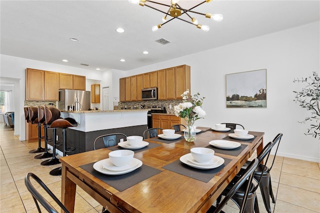 tiled dining area featuring an inviting chandelier