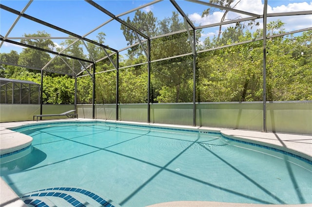 view of pool featuring glass enclosure