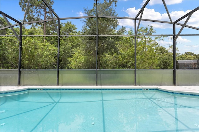 view of pool featuring glass enclosure