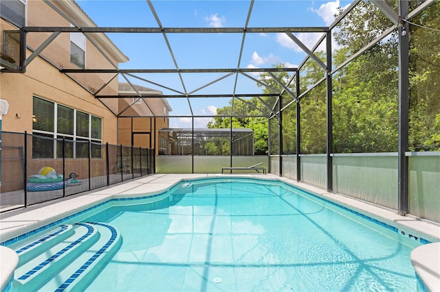 view of swimming pool featuring glass enclosure