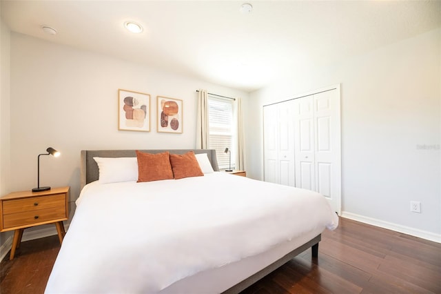 bedroom with dark wood-type flooring and a closet