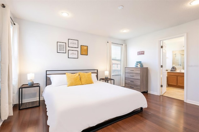 bedroom with dark hardwood / wood-style flooring and ensuite bathroom