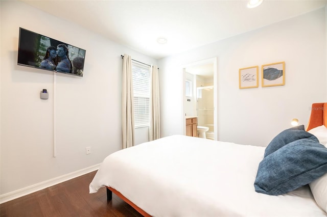 bedroom featuring ensuite bath and dark hardwood / wood-style floors