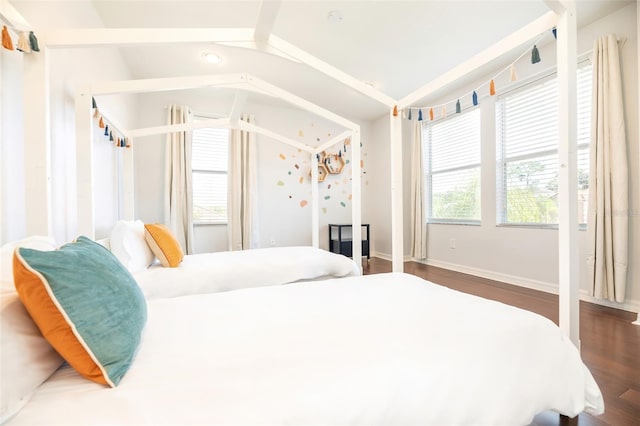 bedroom with dark hardwood / wood-style floors and vaulted ceiling with beams