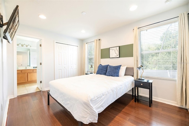 bedroom featuring dark hardwood / wood-style flooring, connected bathroom, sink, and a closet