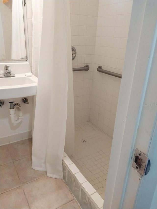 bathroom with a shower with curtain, tile patterned flooring, and sink