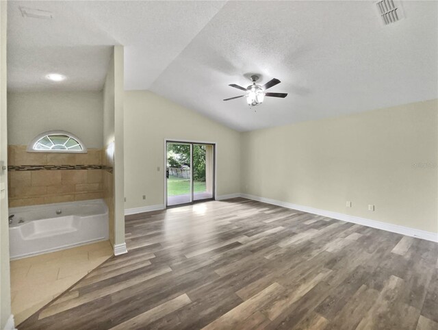 interior space featuring a textured ceiling, wood-type flooring, ceiling fan, and lofted ceiling