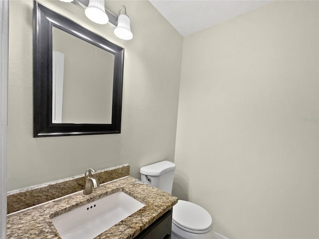 bathroom with vaulted ceiling, toilet, and vanity