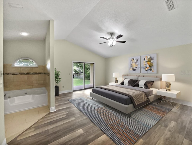 bedroom with hardwood / wood-style flooring, vaulted ceiling, access to outside, ceiling fan, and a textured ceiling