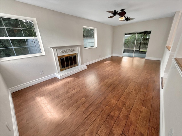 unfurnished living room featuring ceiling fan and hardwood / wood-style floors