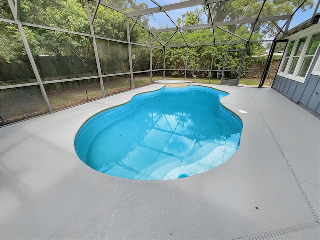 view of swimming pool featuring glass enclosure and a patio area