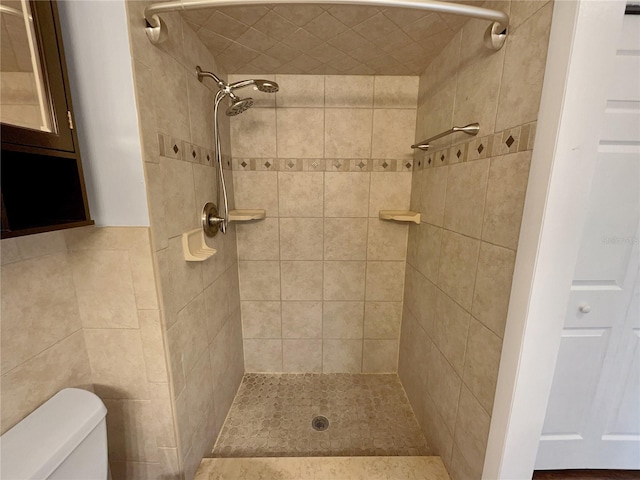 bathroom featuring toilet and a tile shower