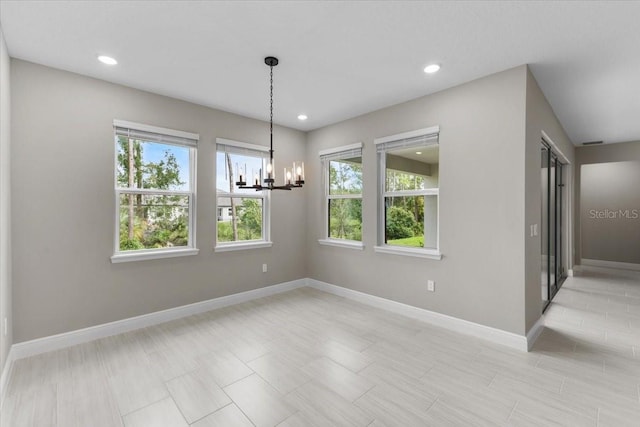 unfurnished dining area featuring an inviting chandelier and a wealth of natural light