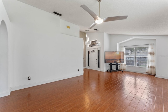 unfurnished living room with a textured ceiling, ceiling fan, wood-type flooring, and lofted ceiling