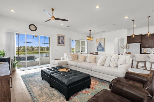 living room with light wood-type flooring and ceiling fan