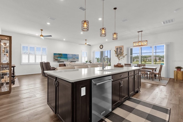 kitchen featuring a wealth of natural light, an island with sink, hanging light fixtures, and hardwood / wood-style flooring