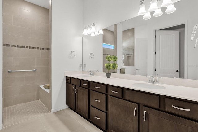 bathroom with a tile shower, vanity, and tile patterned floors