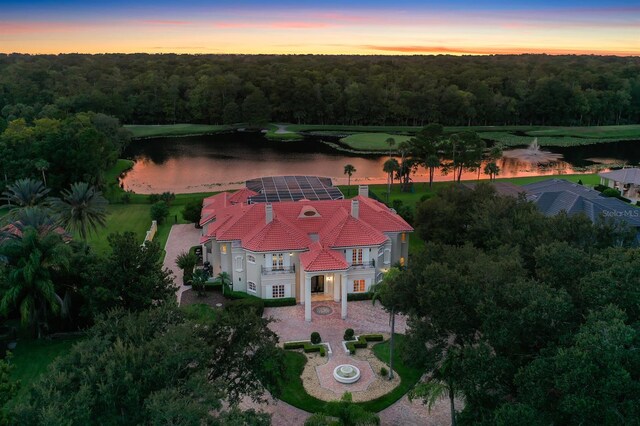 aerial view at dusk featuring a water view