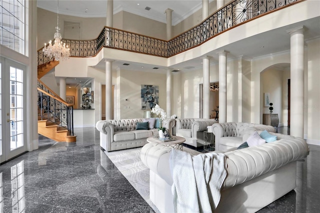 living room with crown molding, a high ceiling, and ornate columns