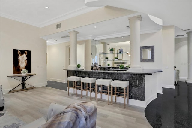 living room with decorative columns, hardwood / wood-style floors, and crown molding