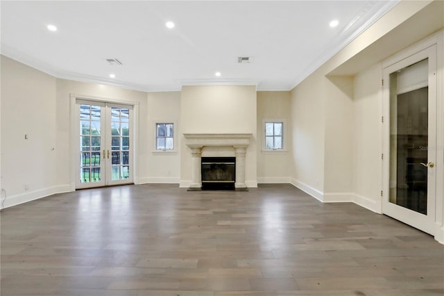 unfurnished living room featuring a premium fireplace, ornamental molding, french doors, and hardwood / wood-style flooring