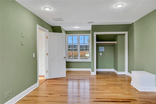 unfurnished bedroom with a closet and light hardwood / wood-style floors