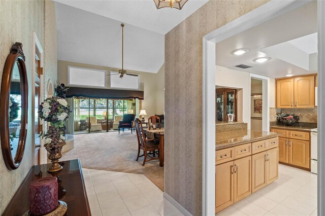 kitchen with light carpet, light brown cabinets, white range, and ceiling fan