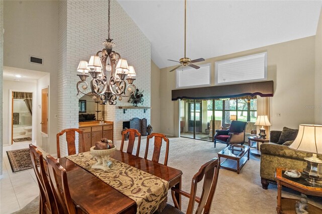 dining room featuring high vaulted ceiling, a brick fireplace, ceiling fan with notable chandelier, and light tile patterned flooring