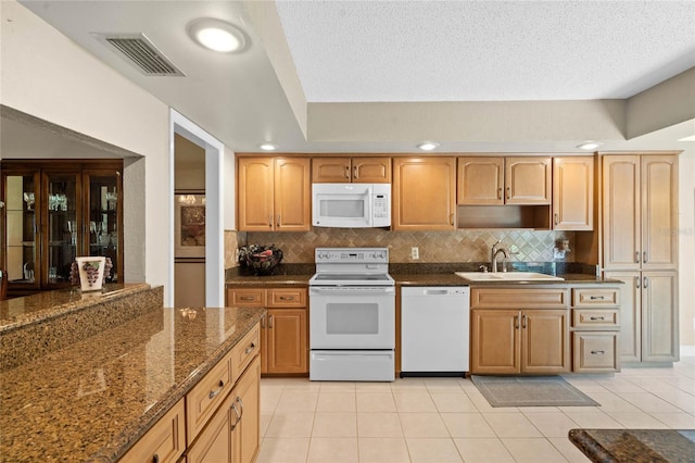 kitchen with white appliances, a textured ceiling, light tile patterned flooring, and sink