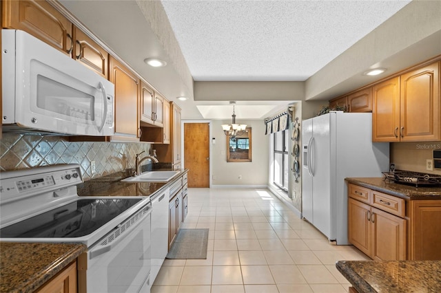 kitchen with light tile patterned floors, sink, white appliances, a notable chandelier, and decorative backsplash