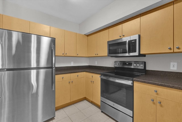 kitchen featuring stainless steel appliances, light tile patterned floors, and light brown cabinets