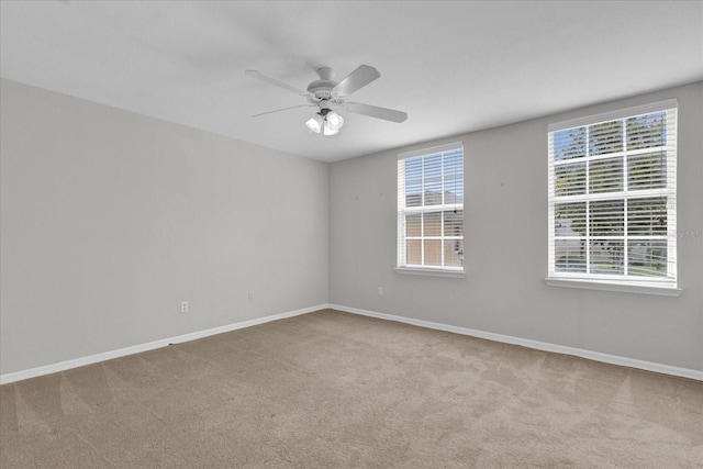 carpeted spare room featuring ceiling fan