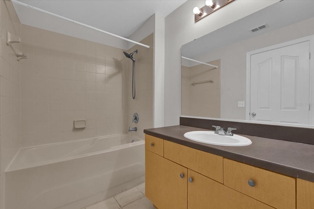 bathroom featuring tiled shower / bath combo, vanity, and tile patterned floors