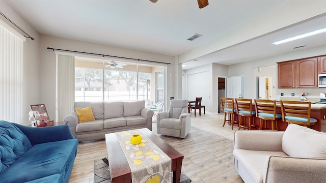 living room featuring light hardwood / wood-style floors and ceiling fan