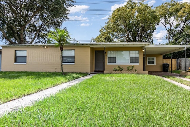 ranch-style house featuring a front lawn and a carport