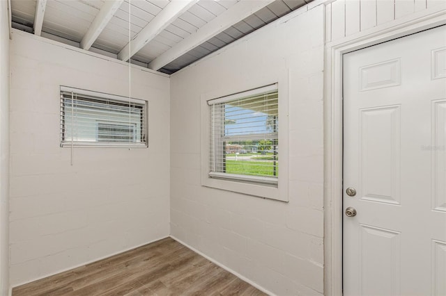 empty room featuring wood ceiling, beamed ceiling, and hardwood / wood-style floors