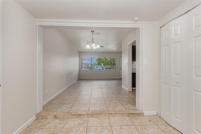 hall featuring an inviting chandelier and light tile patterned floors