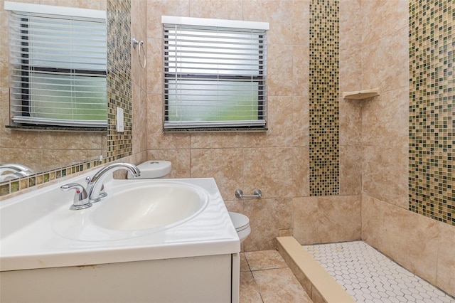 bathroom with walk in shower, tile walls, vanity, and toilet