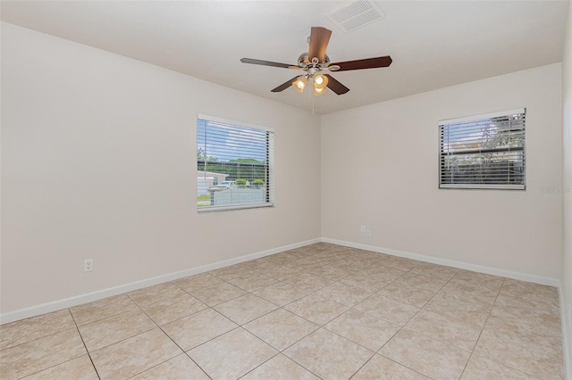 unfurnished room featuring a wealth of natural light, ceiling fan, and light tile patterned floors