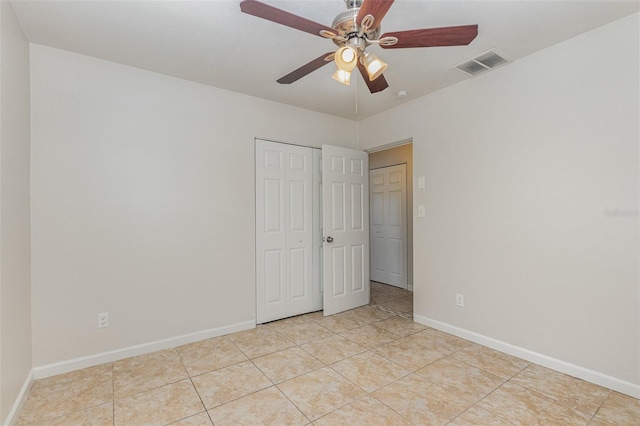 unfurnished bedroom with ceiling fan, a closet, and light tile patterned floors