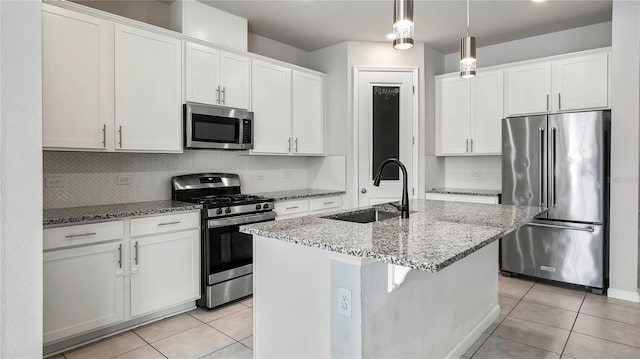 kitchen featuring a kitchen island with sink, sink, stainless steel appliances, and white cabinets