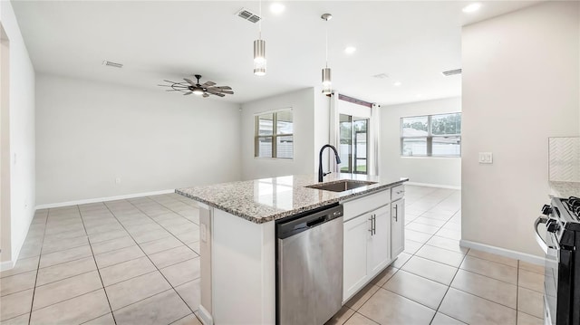 kitchen with white cabinets, an island with sink, sink, appliances with stainless steel finishes, and light stone countertops