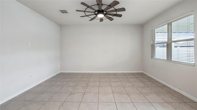 tiled spare room with ceiling fan