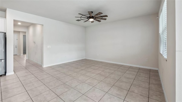 tiled empty room featuring ceiling fan