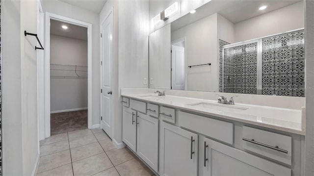 bathroom featuring a shower with door, tile patterned floors, and vanity