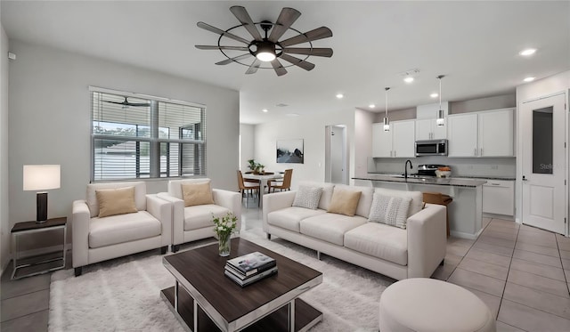 tiled living room with ceiling fan and sink