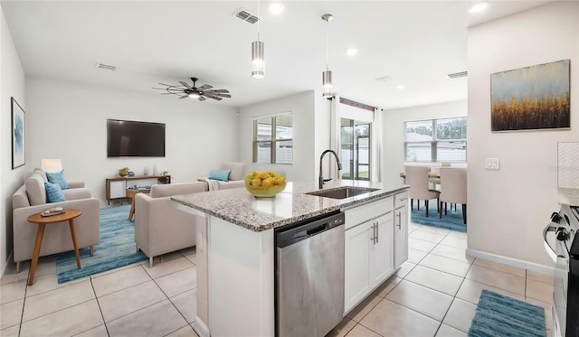 kitchen featuring sink, stainless steel dishwasher, an island with sink, a wealth of natural light, and white cabinetry