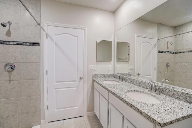 bathroom featuring a tile shower, tile patterned floors, and vanity